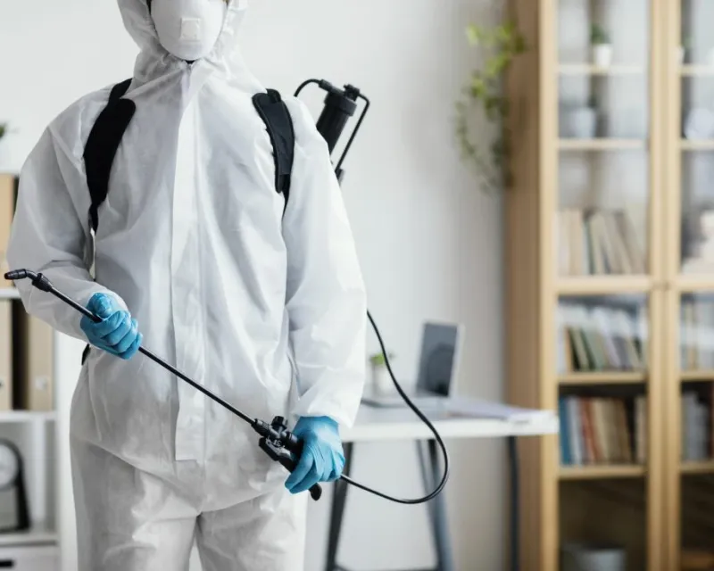 PestMan technician in PPE preparing a treatment